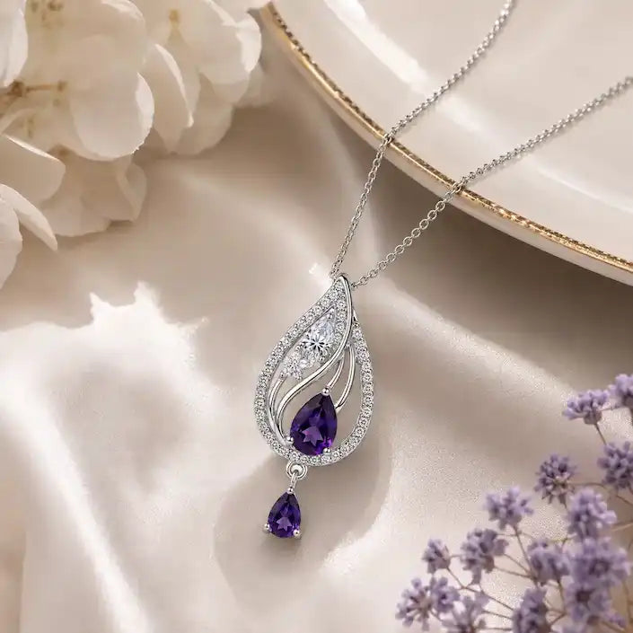 Silver teardrop pendant necklace featuring a pastel pink quartz stone center and a small dangling pink teardrop charm, accented with clear pavé crystals.