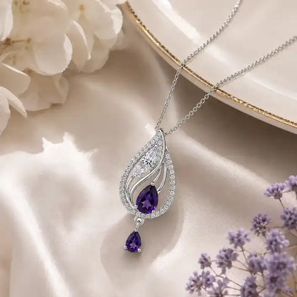 Silver teardrop pendant necklace featuring a pastel pink quartz stone center and a small dangling pink teardrop charm, accented with clear pavé crystals.