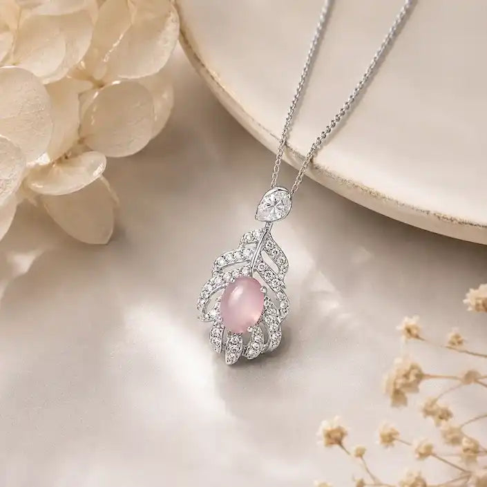 Silver leaf design pendant necklace featuring a vibrant oval pink tourmaline center stone accented by sparkling pavé crystal embellishments.